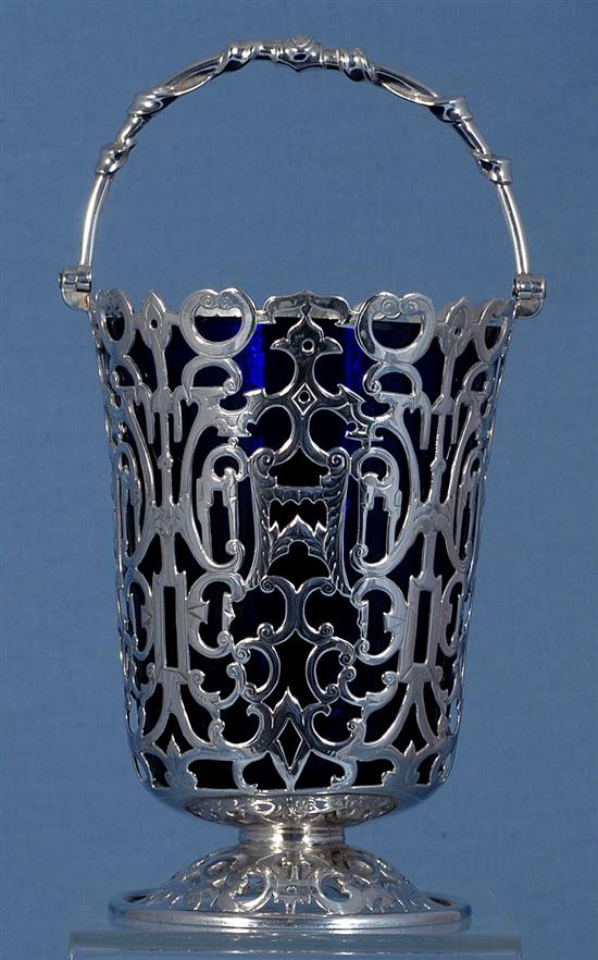 An early Victorian silver swing handled sugar basket and blue glass liner, Height: to handle 7 ¾”/195mm Top Dia 4”/100mm